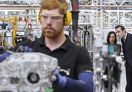 Un trabajador de Horse ajusta un motor en la factoría de Valladolid durante una visita del ministro de Economía, Carlos Cuerpo (d), a finales del año pasado.