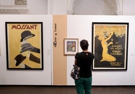 Una visitante observa carteles de la exposición.