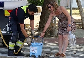 Una mujer recoge agua, este miércoles, de un camión nodriza de los Bomberos de Segovia en la plaza Centro Segoviano.