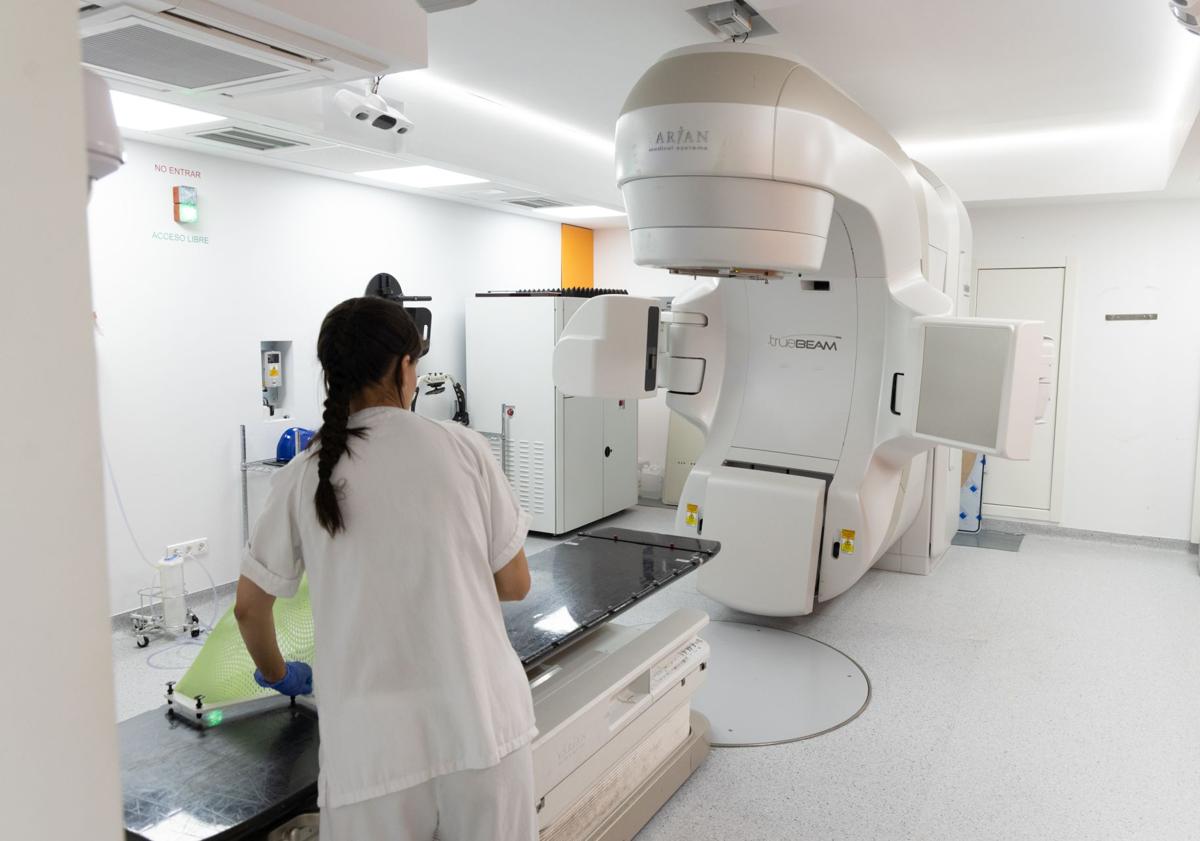 Imagen principal - Sala de uno de los aceleradores lineales del Clínico, entrada que da acceso a dos de los equipamientos de radioterapia e imagen del paciente que recibió el primer tratamiento del alta precisión SBTR.