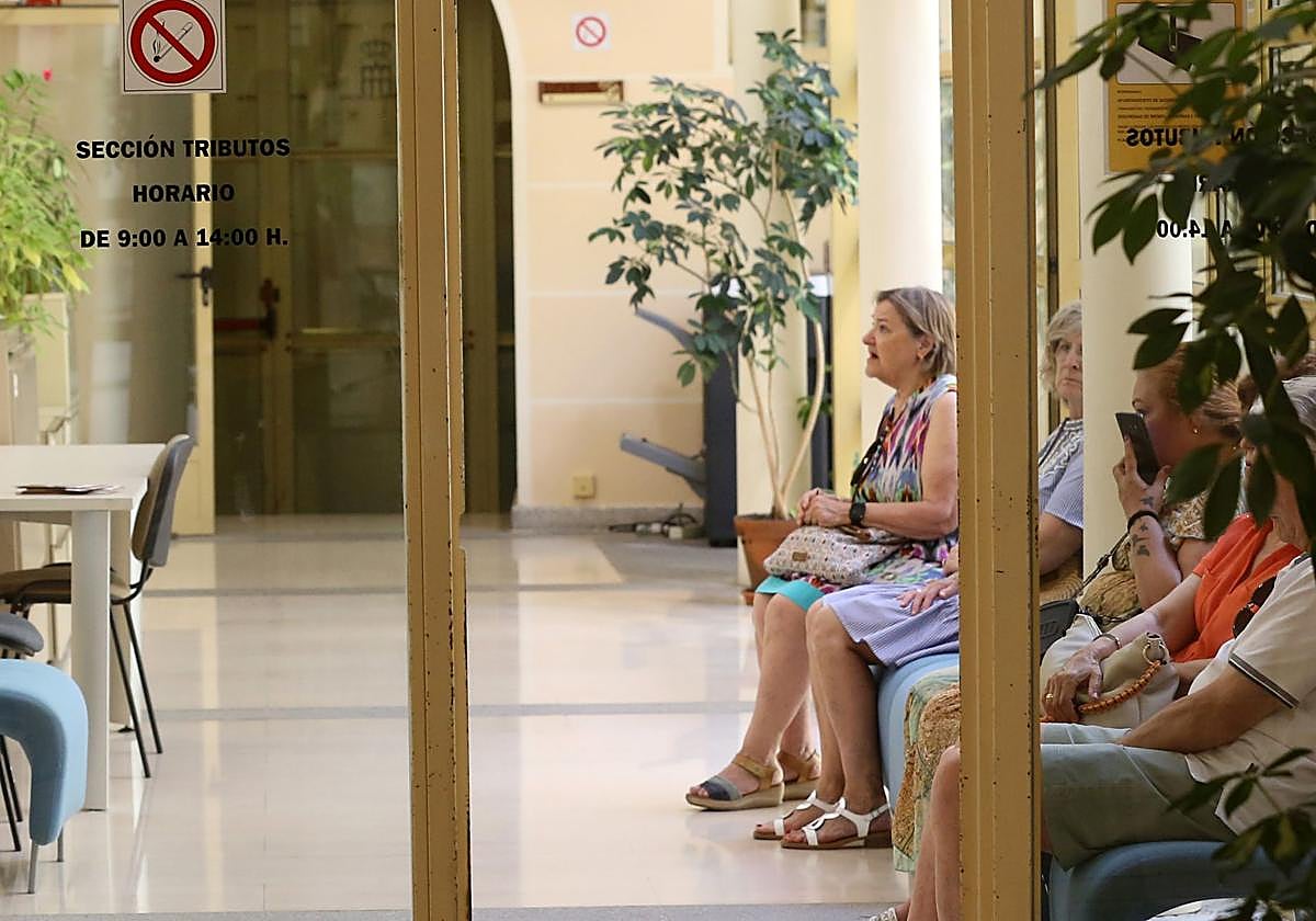 Ciudadanos esperan en la sección de Tributos en el Ayuntamiento de Segovia.