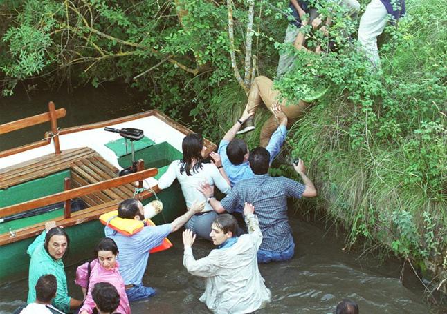 Los pasajeros de la barca salen del cauce del Canal de Castilla tras superar las corriente de la esclusa en la que volcó.