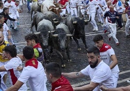 Varios mozos son perseguidos por los toros en el sexto encierro de San Fermín.