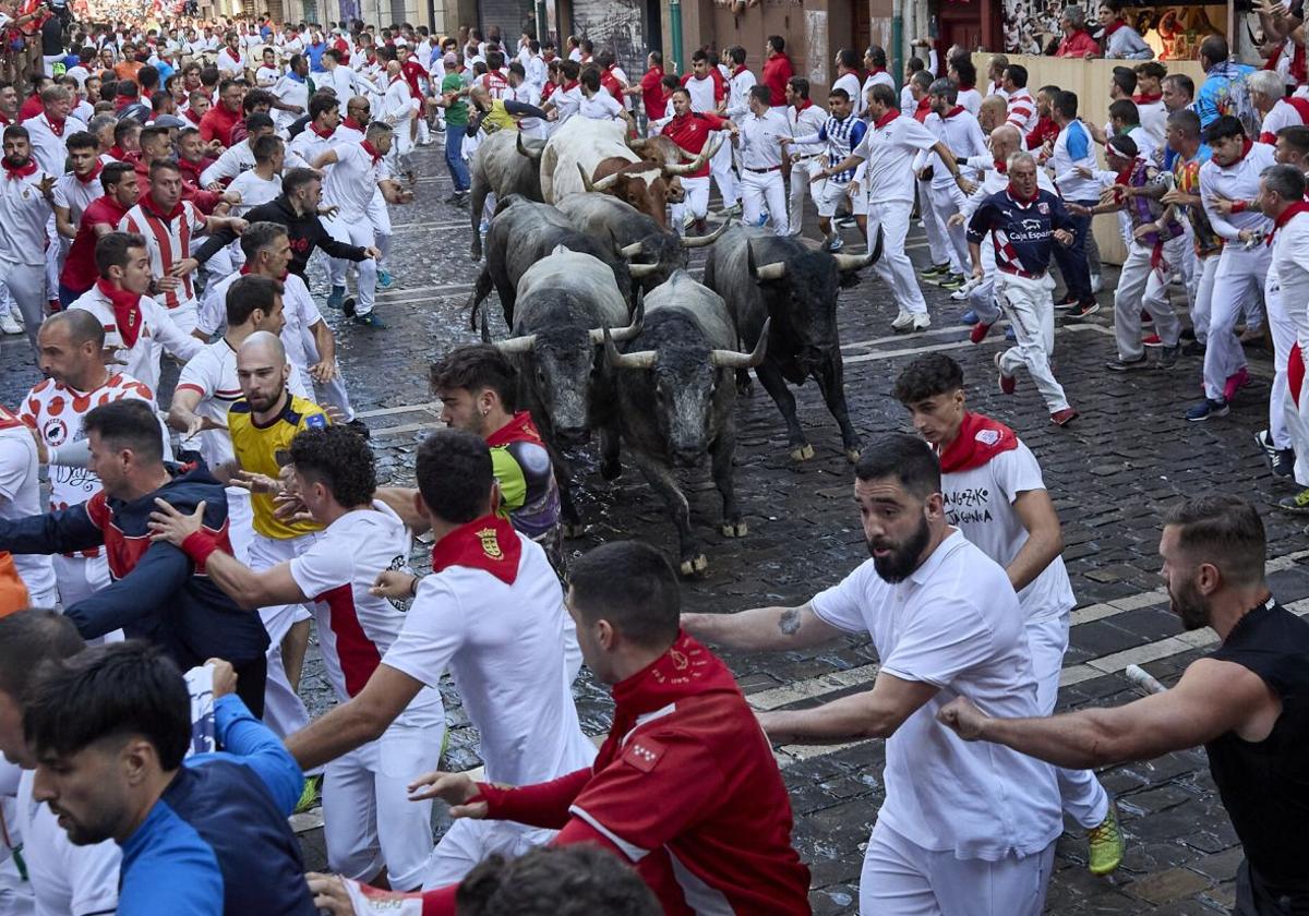 Varios mozos son perseguidos por los toros en el sexto encierro de San Fermín.