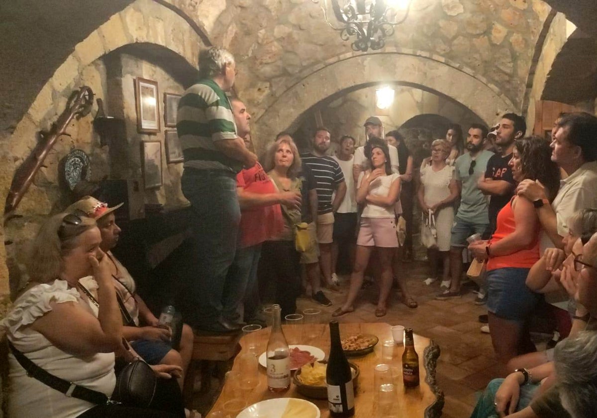 Un grupo de personas atienden a las explicaciones de Timoteo Escudero en la peña La Chispa