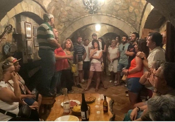 Un grupo de personas atienden a las explicaciones de Timoteo Escudero en la peña La Chispa