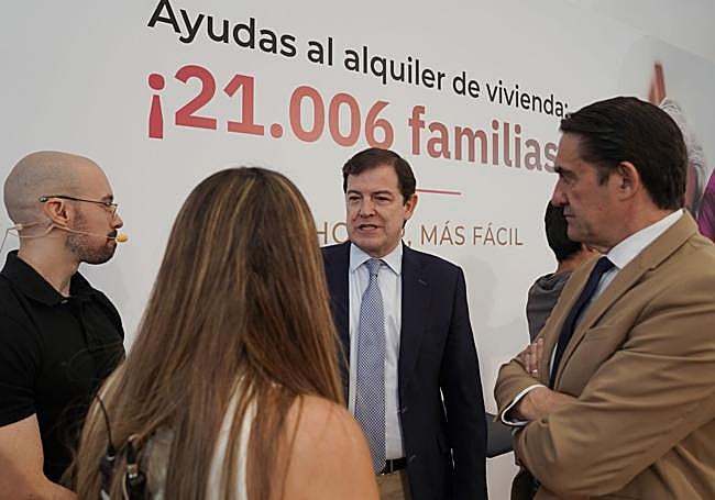 El presidente de la Junta y el consejero de Vivienda, junto con beneficiarios de las ayudas en un acto público para anunciar la resolución.