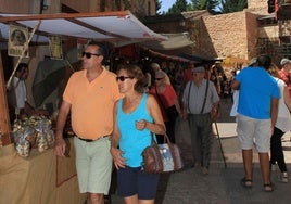 Multitud de personas participan en un evento celebrado en un pueblo de Segoia en época estival.
