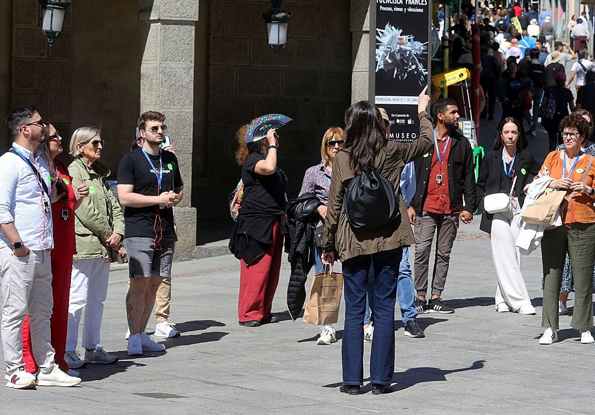 Una guía realiza una visita por el centro de Segovia a un grupo de turistas.