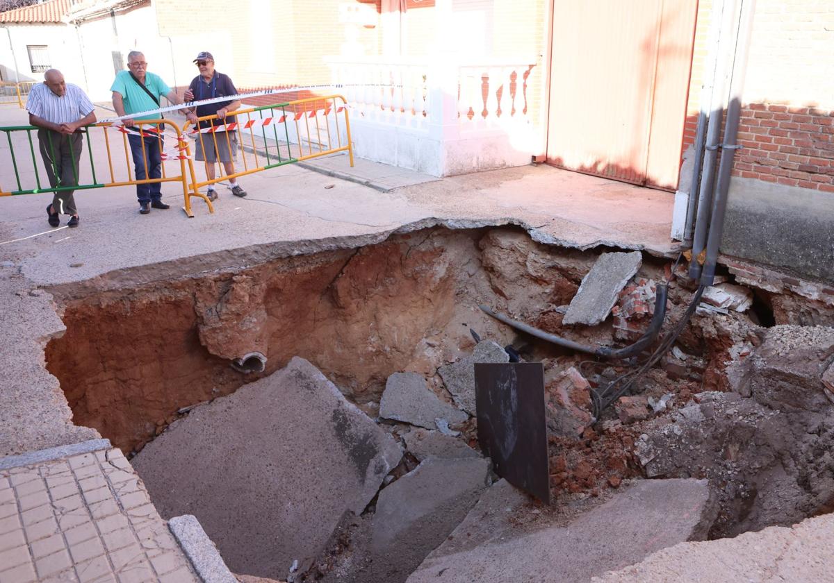 Tres personas observan el socavón en Rodilana, localidad cercana a Medina del Campo, tras las tormentas del 4 de julio.