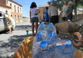 Imagen de archivo de unos vecinos llevando botellas de agua en un pueblo de Segovia.