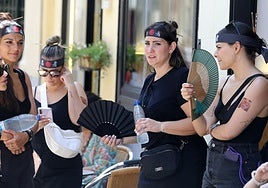Unas jóvenes usan abanicos y agua para soportar el calor que hace estos días en Segovia.
