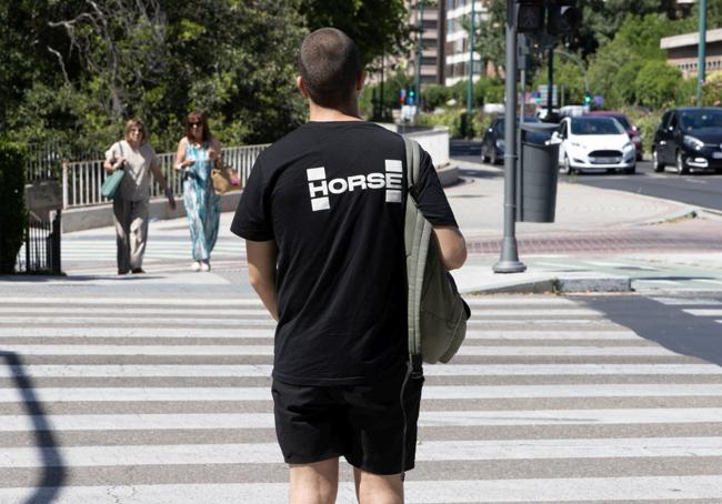 Un ciudadano con una camiseta de Horse se dispone a cruzar un paso de peatones junto a la avenida de Isabel la Católica de Valladolid.