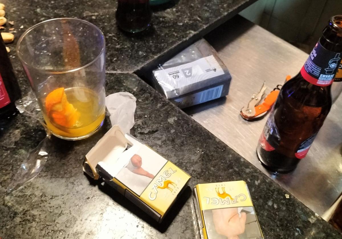 Cajetillas de tabaco y restos de bebidas que se encontraron los agentes a su llegada al bar.