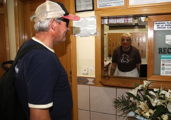 El demandante de ayuda a Cáritas consulta el precio de una habitación en un hostal.