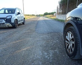 Dos coches se cruzan en el tramo sin asfaltar el camino en el tramo entre el polígono y La Cistérniga.