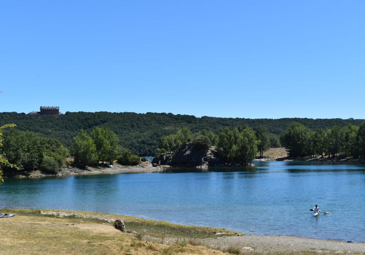 Un piraguista disfruta del embalse de Ruesga y al fondo, el parador.