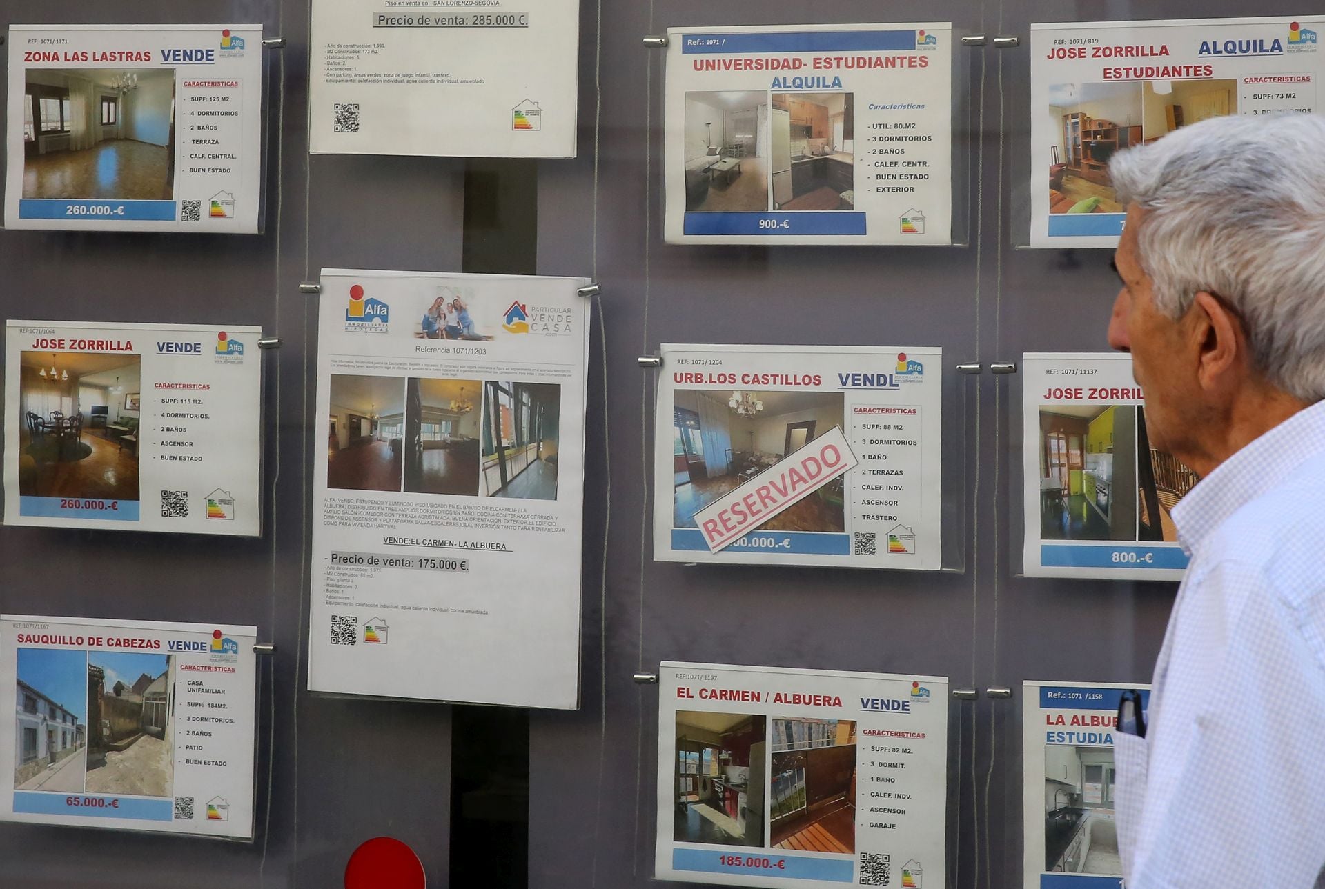 Un hombre pasea junto a los anuncios de una inmobiliaria en Segovia.