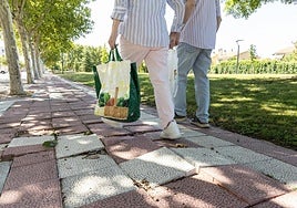 Dos vecinos de Santa Ana vuelven a casa esquivando los adoquines levantados de la calle Barcelona.