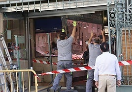 Los operarios colocan las nuevas puertas, en el acceso a la plaza desde la calle Joaquín Costa.