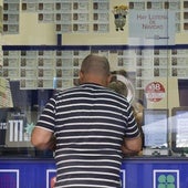 Un hombre adquiere un décimo en un despacho de loterías.