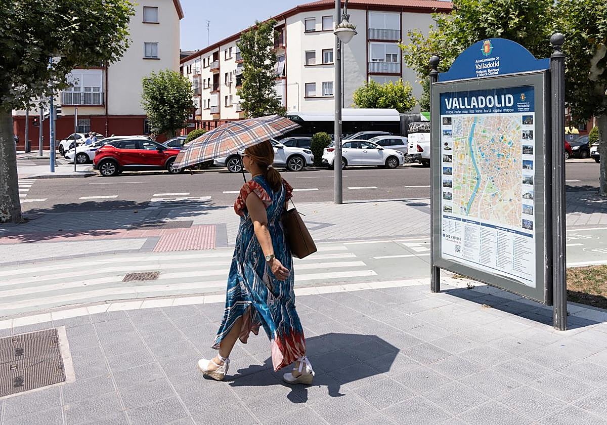 Una mujer se protege del sol con un paraguas en el centro de Valladolid.