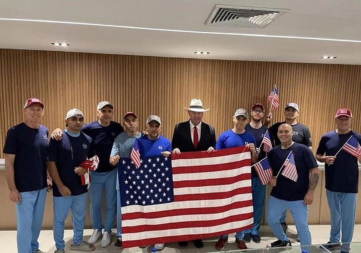 Los estadounidenses liberados tras el intercambio, posan con la bandera de EE UU.