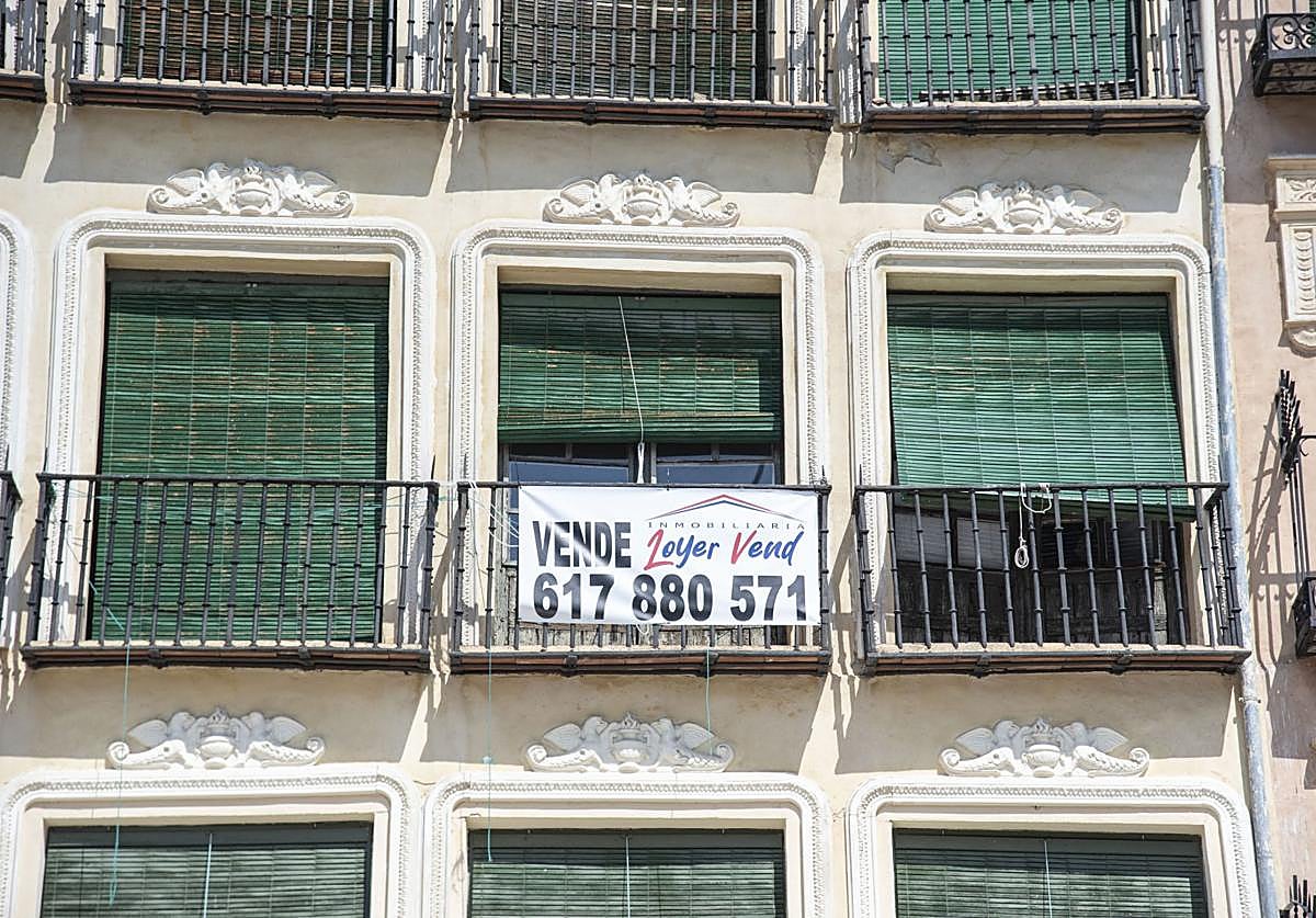 Cartel de 'se vende' colocado en el balcón de una vivienda del casco histórico de Segovia.