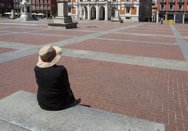 Una mujer descansa en un banco de la Plaza Mayor de Valladolid.