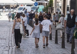 Varias personas pasean por una céntrica calle de Segovia.