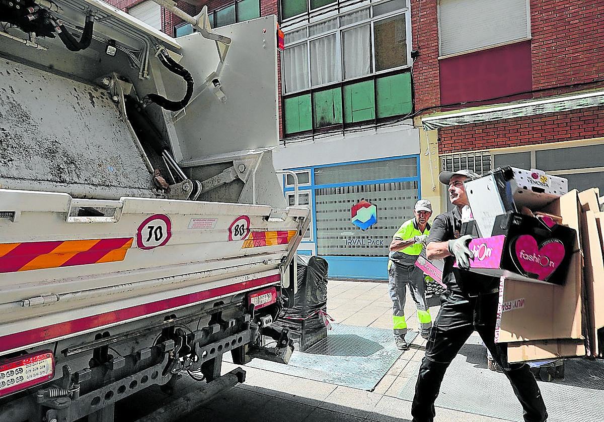 Los operarios retiran el cartón acumulado en la calle Mayor Antigua para depositarlo en el camión.