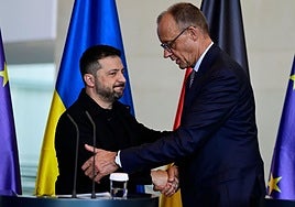El presidente de Ucrania Volodymyr Zelensky y el canciller alemán Friedrich Merz se dan la mano.