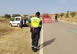Un agente de la Guardia Civil y una grúa en el lugar del suceso.