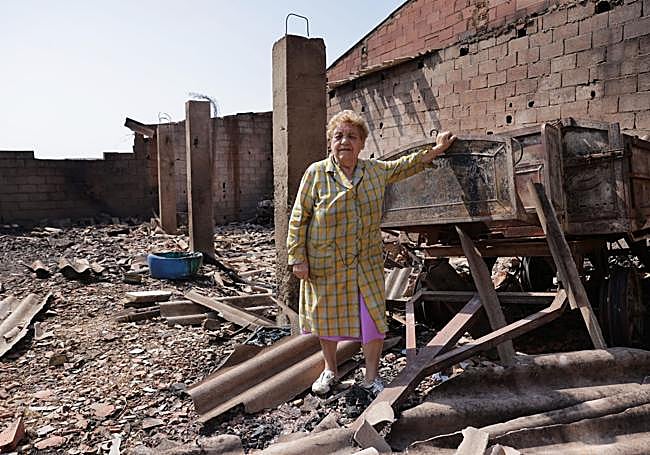 Una de las vecinas vuelve juntos a los escombros cuando ya ha pasado el incendio.