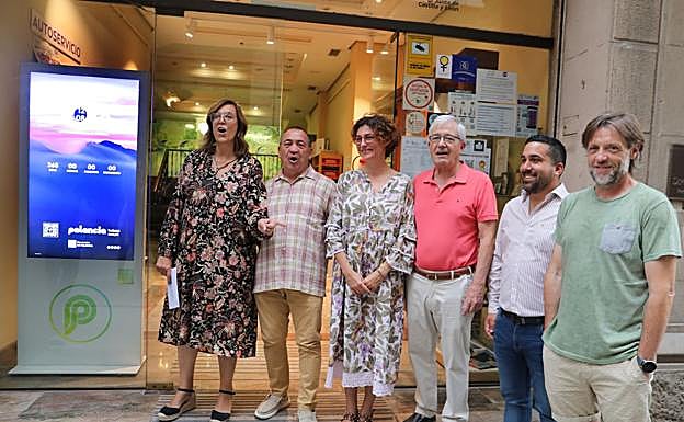 La presidenta de la Diputación y otros representantes institucionales, junto al totem instalado en la Oficina de Turismo.