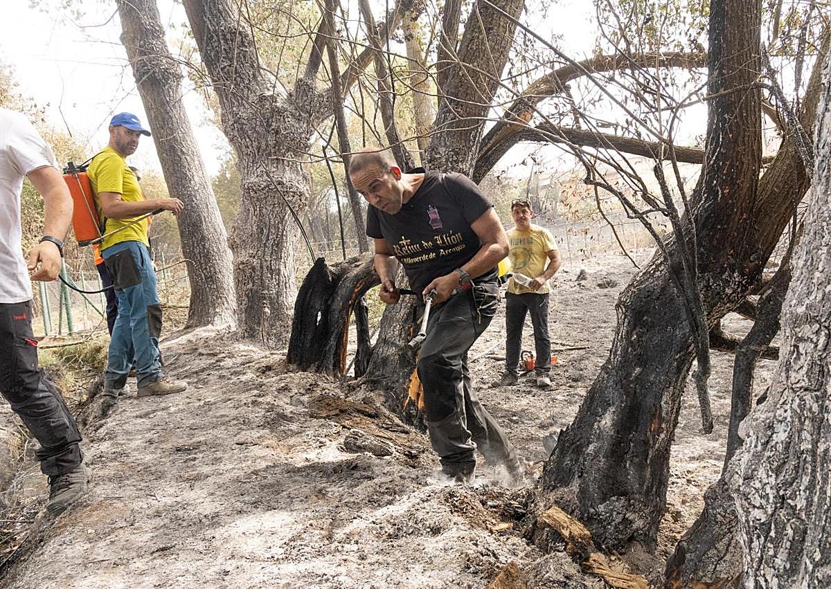 Imagen secundaria 1 - Los vecinos ayudan en Santa Marina de Valdeón, Canalejas y, en último término, el paisaje calcinado junto a la localidad.