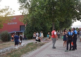 La ministra, a la derecha, conversa con la Policía, junto al polideportivo de Guardo.