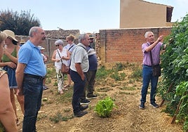 Varias personas atienden las explicaciones en la visita a un huerto de la localidad