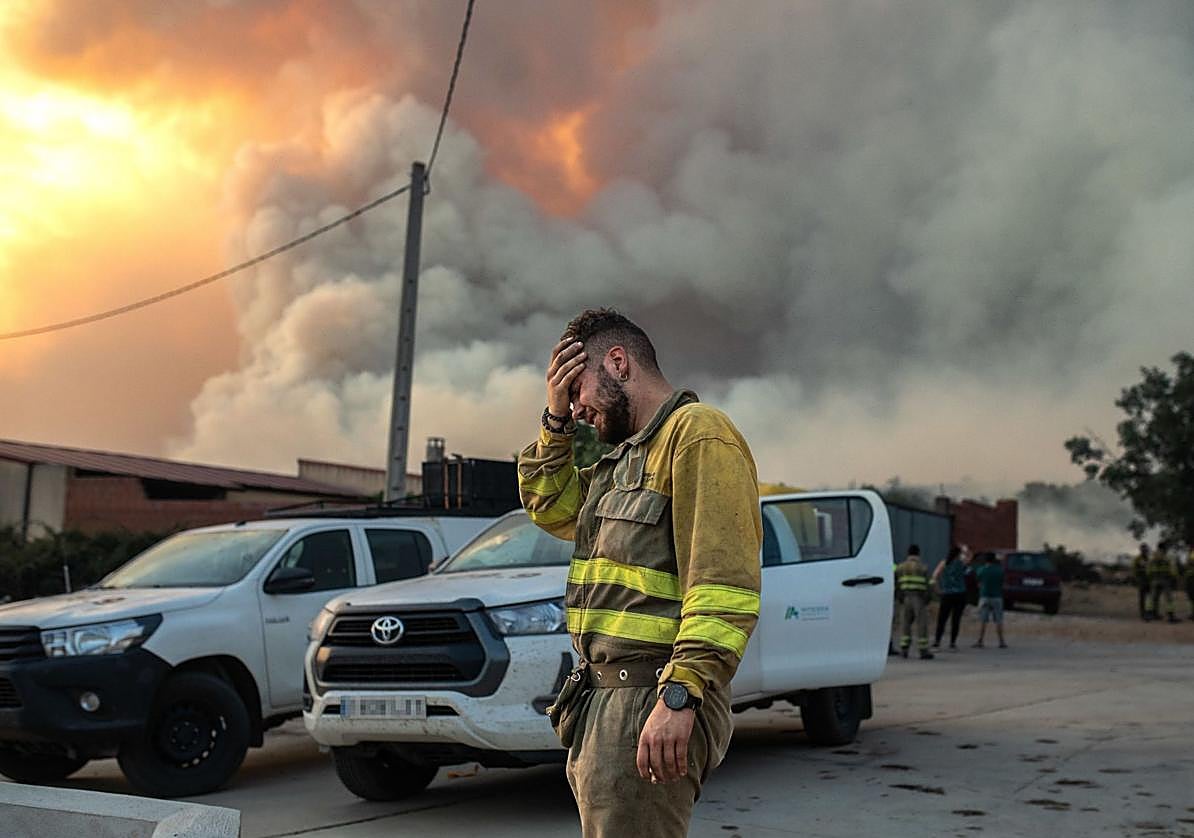 Uno de los bomberos se lleva las manos a la cara.