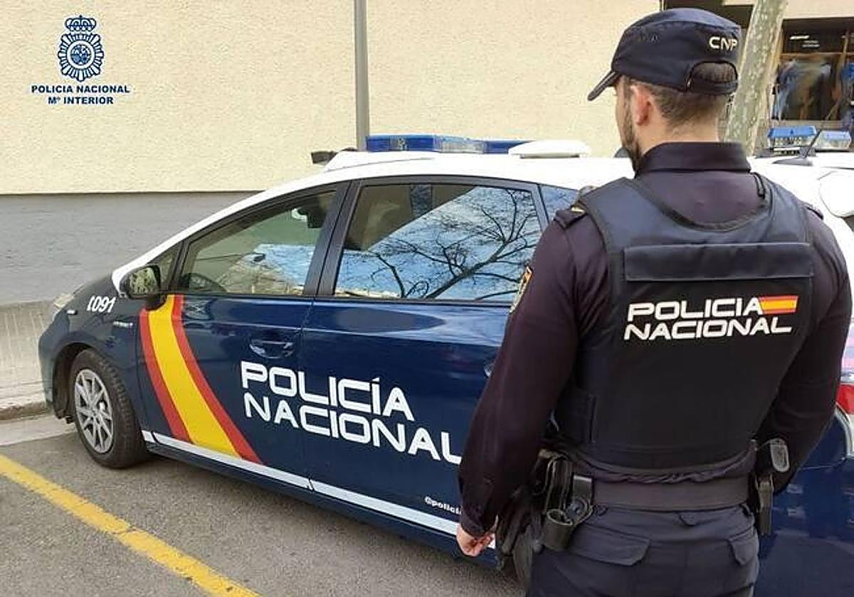 Policía nacional junto a su vehículo.