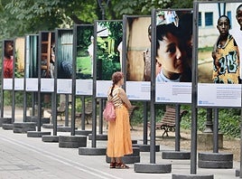 Una paseante se detiene a observar la exposición de Aldeas Infantiles SOS 'Juntos porque somos hermanos'.