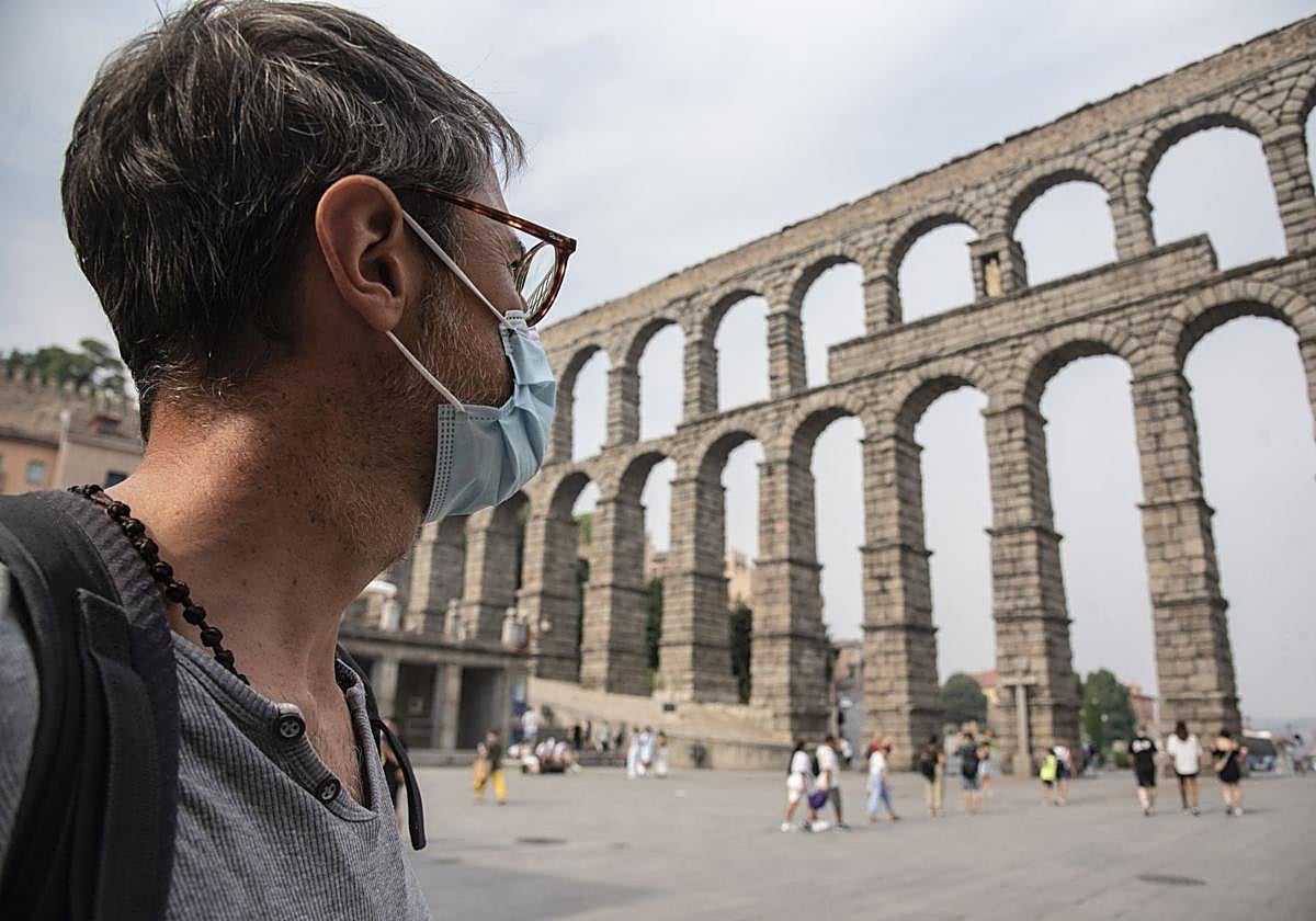 Un hombre con mascarilla cruza el Azoguejo.
