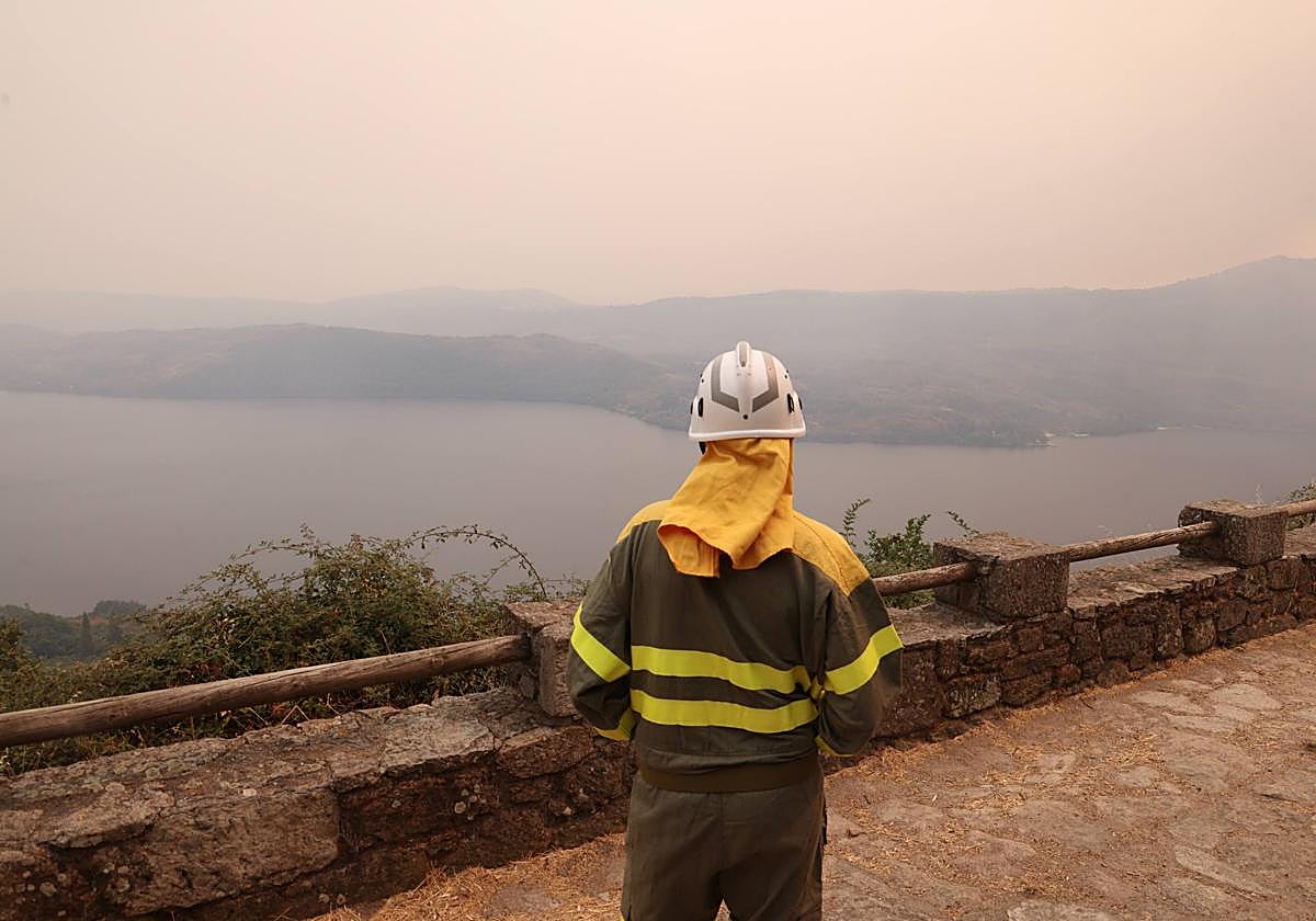 Un agente forestal observa el lago de Sanabria desde la localidad de San Martin de Castañeda.
