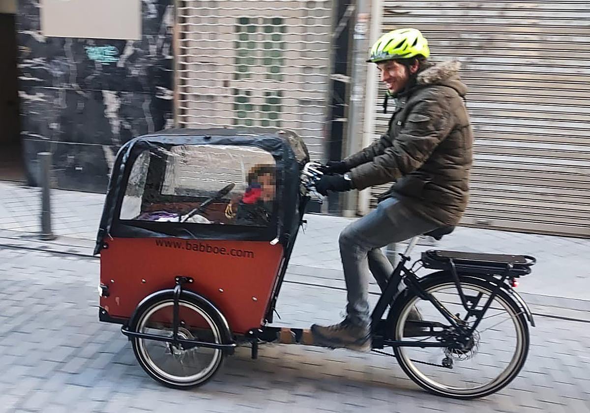 Daniel de Santiago lleva a un pasajero en la bicicleta de carga.