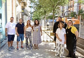 Propietarios y empleados de varios negocios de Gamazo posan junto a las vallas de la obra.