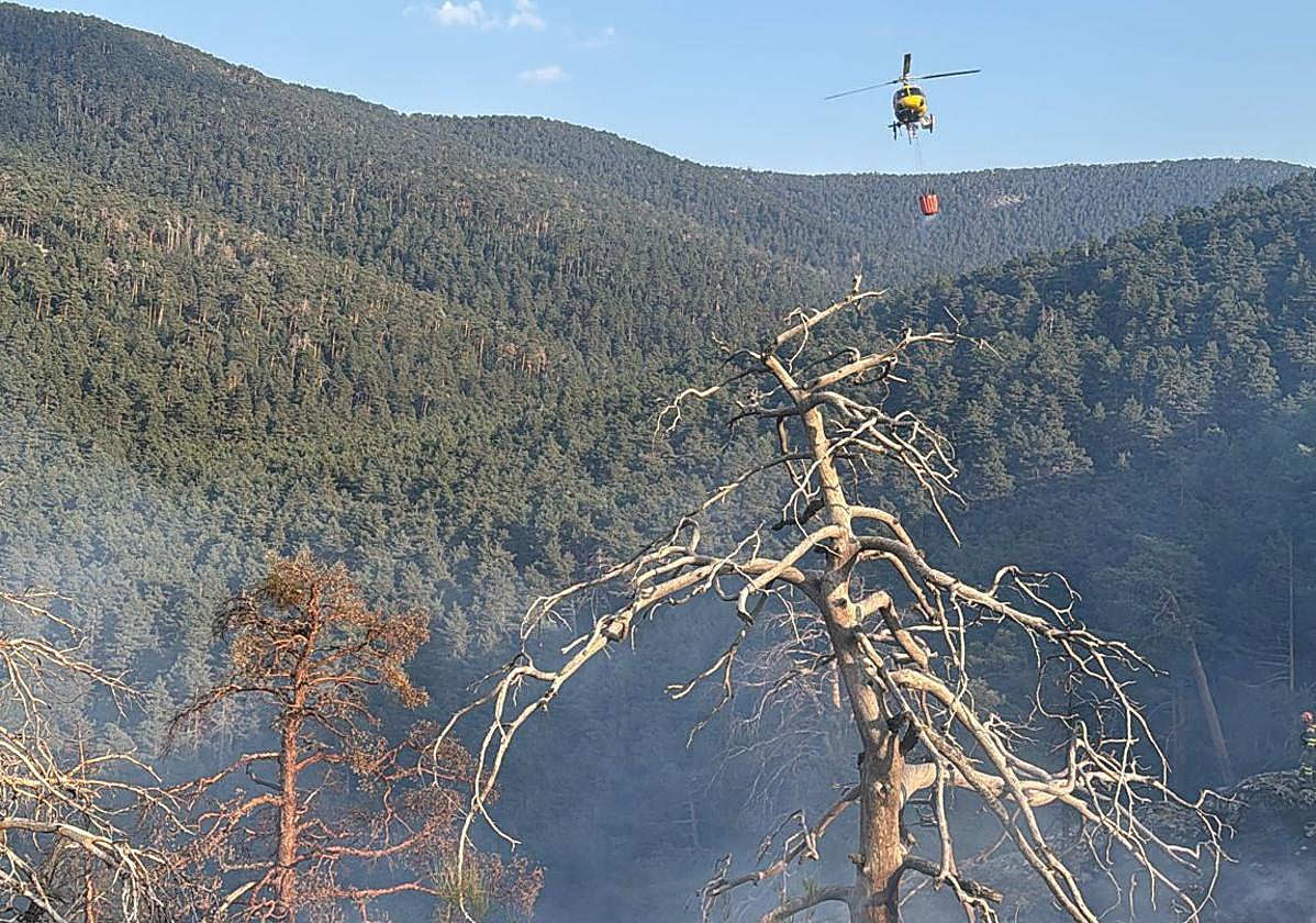 Un helicóptero participa en las labores de extinción del incendio en la sierra de Guadarrama.