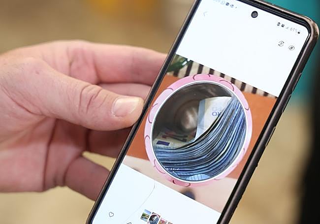 David mostrando una foto que hizo del interior de la lata con los billetes.