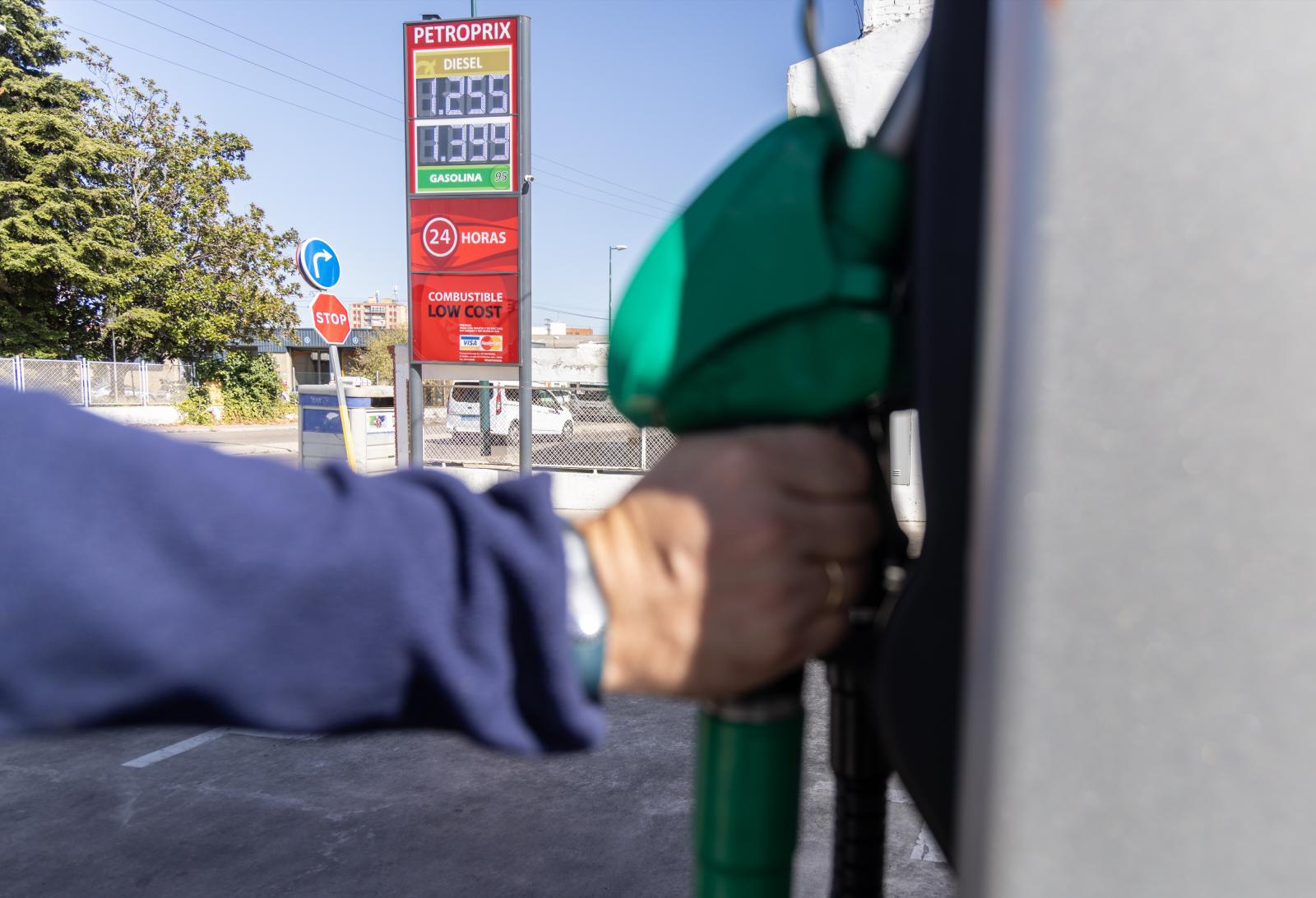Un hombre coge un surtidor de gasolina en Valladolid.