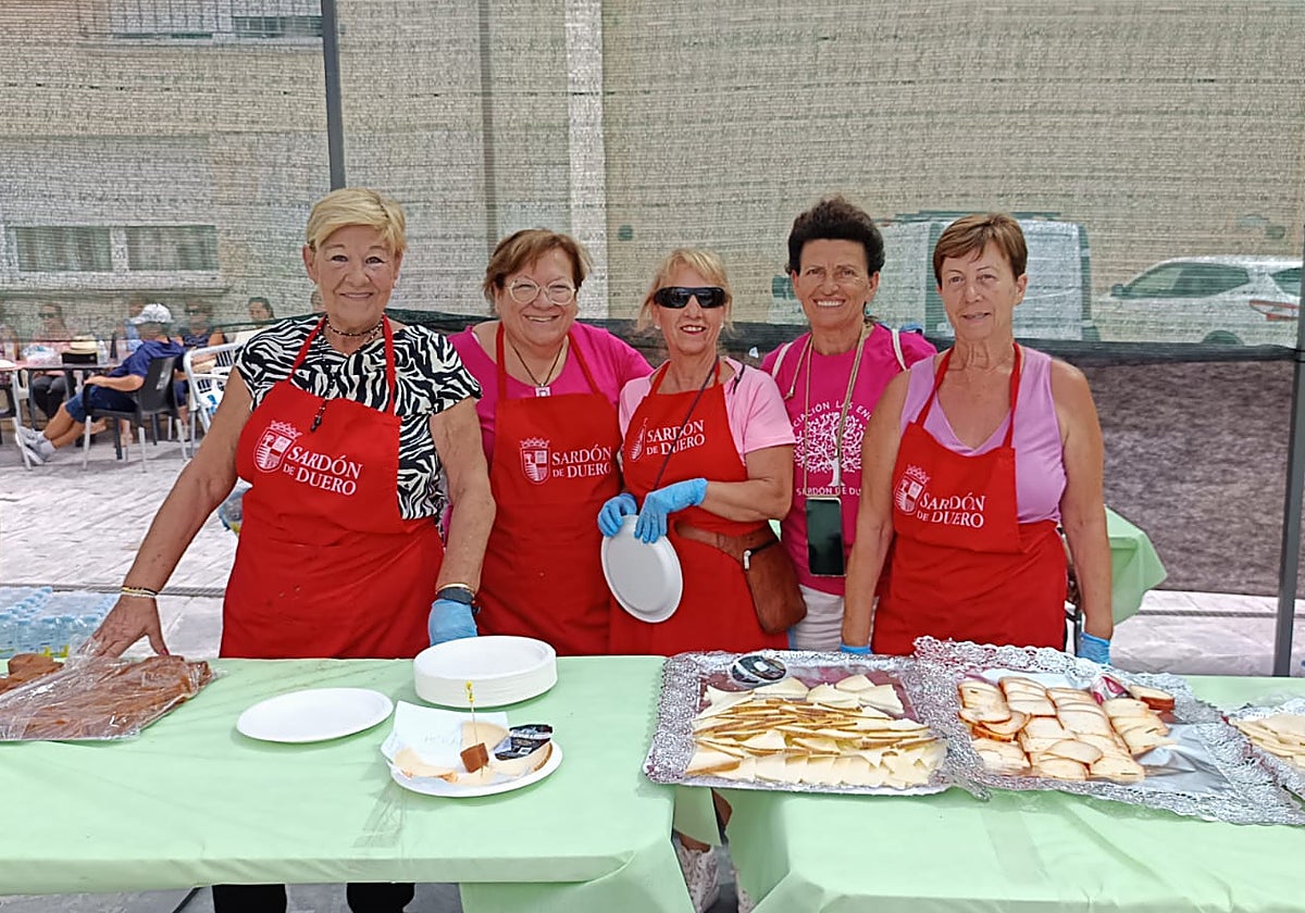 Un grupo de mujeres repartan las tapas de queso en la pasada edición