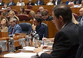 Fernández Mañueco toma notas en su escaño en el pleno de los incendios. El consejero Suárez-Quiñones, al fondo.